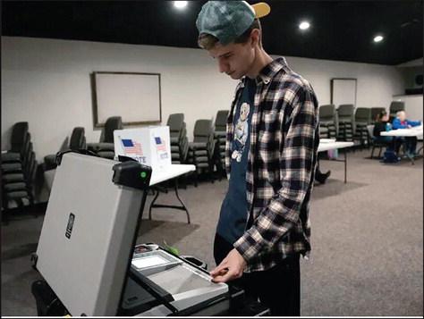 University of Oklahoma student Blake Hiebert, 22, sends his ballot into a machine at his Norman polling station after voting. Less than 10% of Oklahoma voters 30 and under participated in that election. Whitney Bryen/Oklahoma Watch