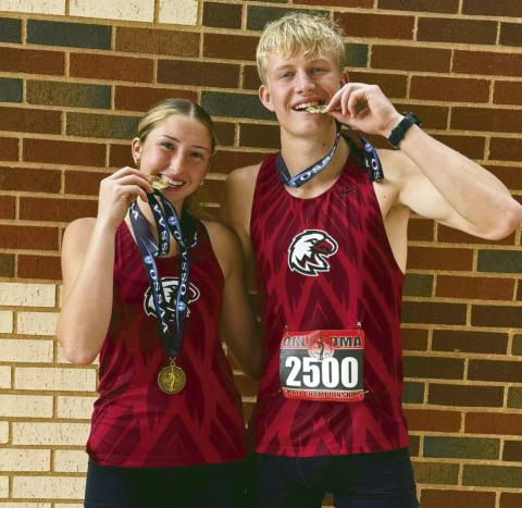 Reese Coleman (L)and Brayden Cowan (R) ham it up with their state championship gold medals after the state cross country meet Saturday. Cowan had previously won a gold in track while Coleman was a runnerup.