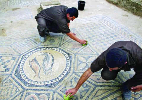 PRISONERS WORK AT A NEARLY 1,800-YEAR-OLD DECORATED FLOOR FROM AN EARLY CHRISTIAN PRAYER HALL DISCOVERED BY ISRAELI ARCHEOLOGISTS. (AP PHOTO/ARIEL SCHALIT, FILE)