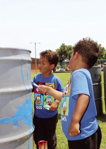 These twins are having an awesome time helping out the city by sprucing up the trash barrels for the city parks. The painting was part of the kids’ carnival at the Watonga Public Library. Photo by Connie Burcham